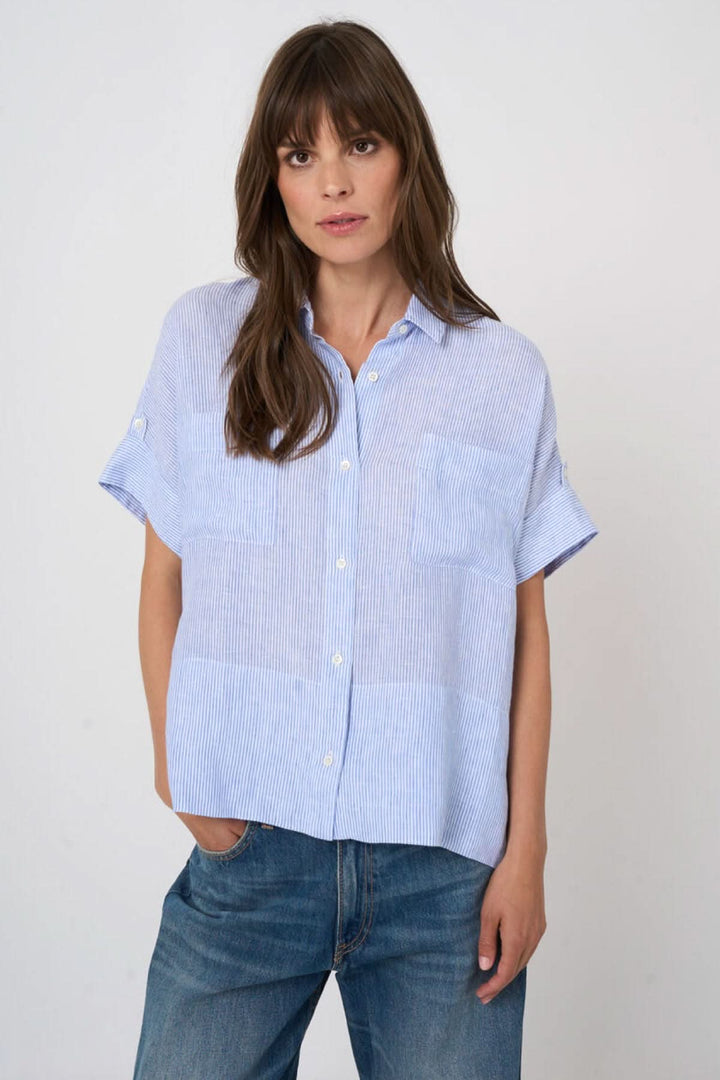 Blouse en lin à rayures fines, manches courtes, col classique, tenue décontractée sur mannequin, fond blanc.