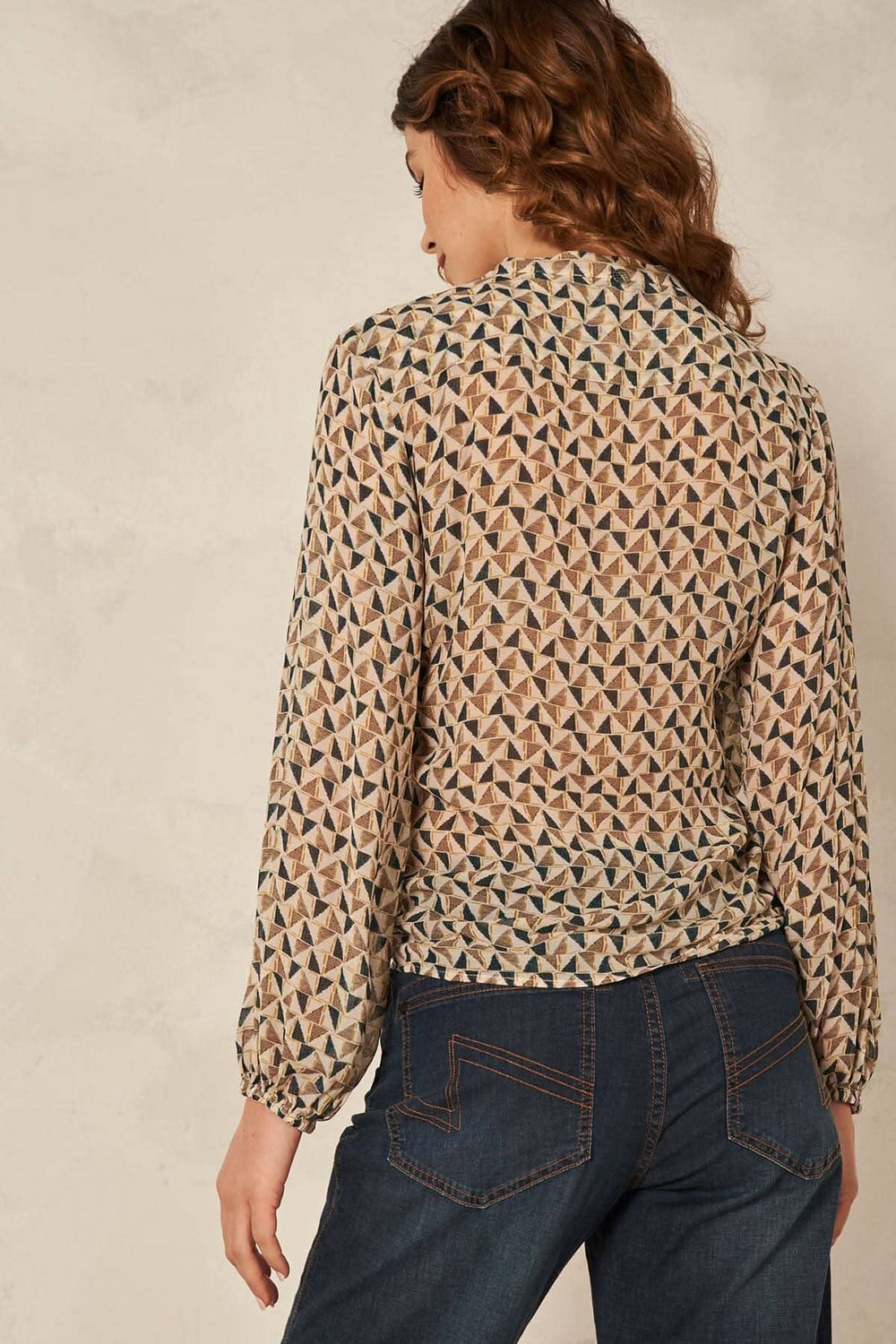 Blouse enveloppée à imprimé géométrique, vue arrière, manches longues et encolure en V, style sophistiqué.