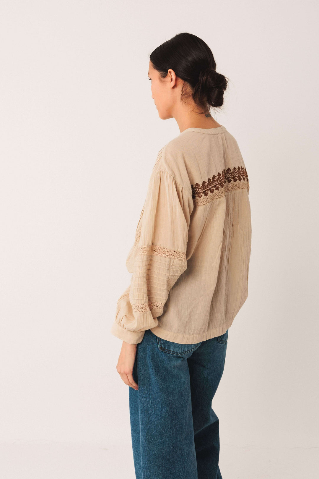 Blouse ethnique brodée beige avec manches longues et détails plissés vue de dos.