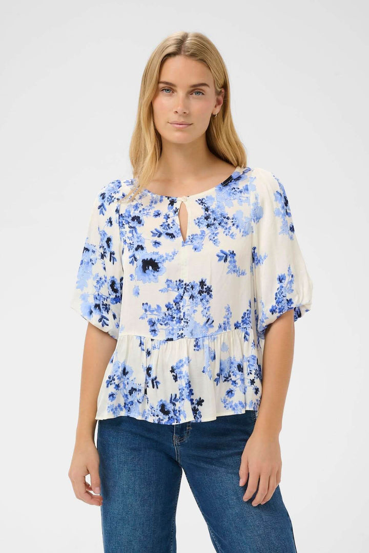 Blouse fleurie Azelia portée par modèle, chemisier fluide à imprimé floral, coupe évasée, encolure arrondie.