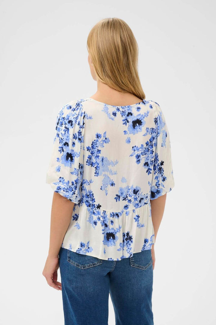 Blouse fleurie Azelia vue de dos avec imprimé floral bleu, coupe évasée et taille froncée, porté avec un jean pour un look décontracté.