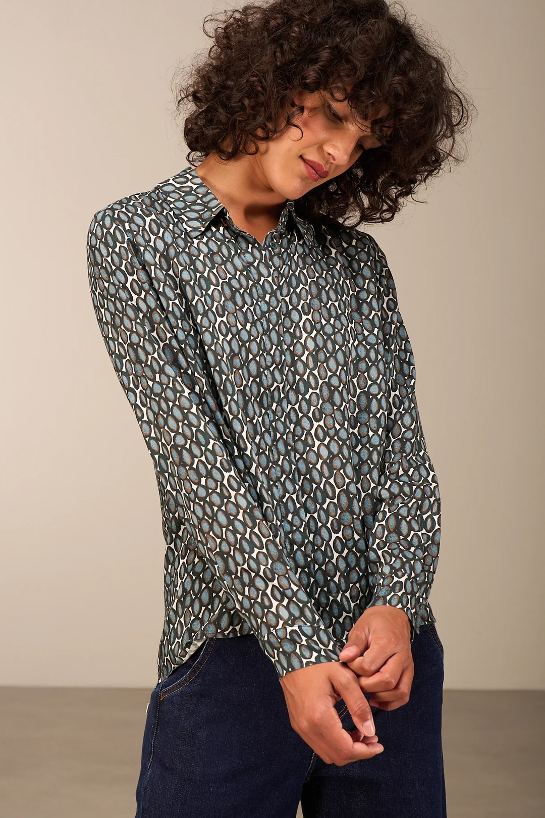 Femme portant une blouse fluide à motif avec col chemise classique, coupe droite, idéale pour le bureau ou sorties décontractées.