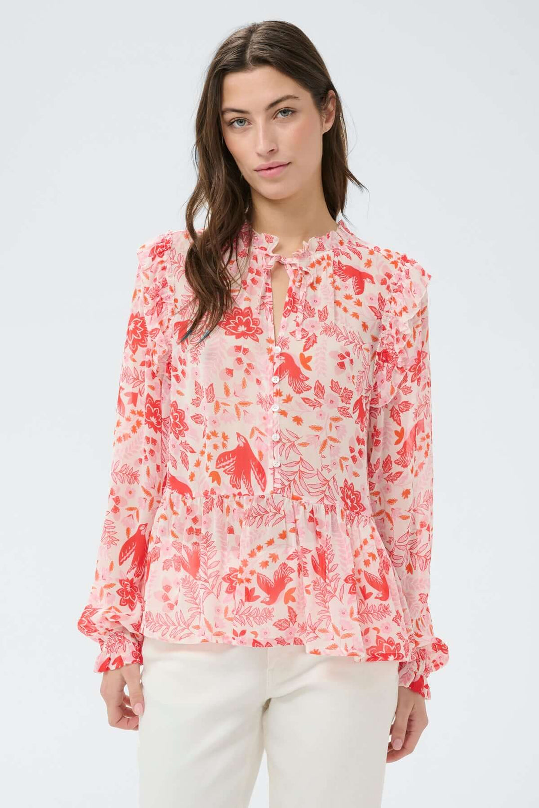 Femme portant une blouse fluide à encolure fendue Alfrida avec un imprimé délicat sur fond blanc.