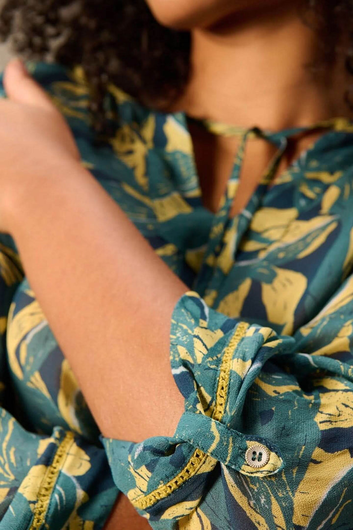 Blouse fluide imprimé avec manches 3/4, détails de tissu à motif végétal, encolure avec lien, idéale pour un style décontracté.