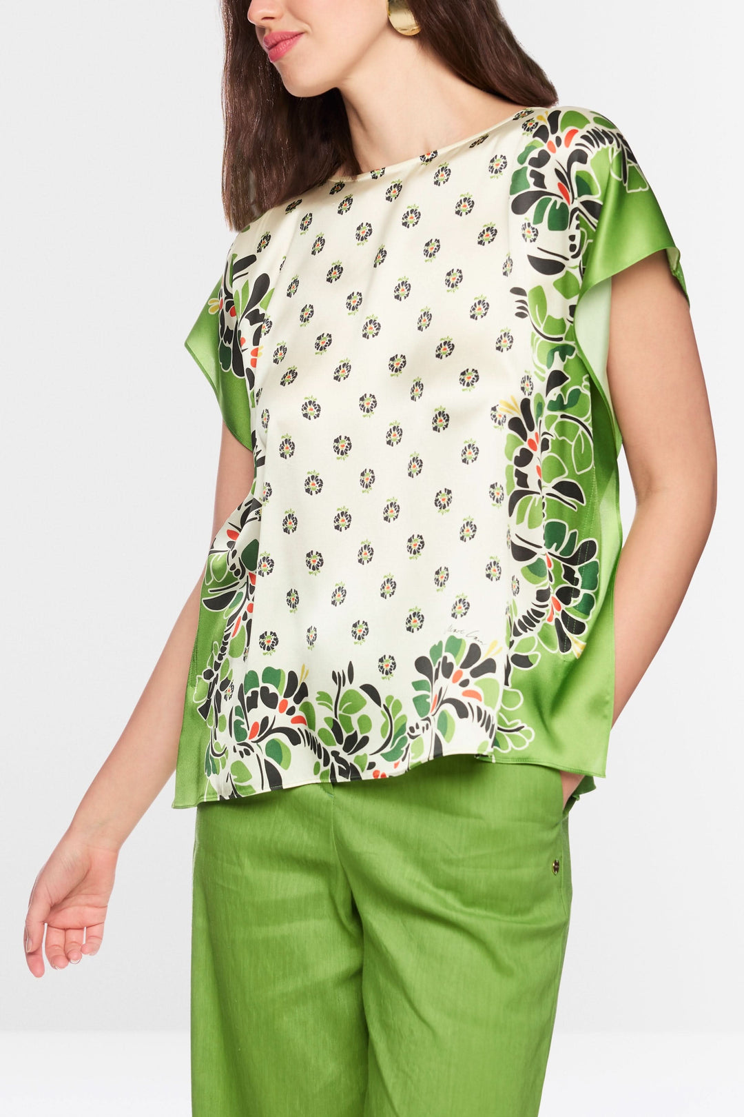 Blouse fluide imprimée avec motif délicat, manches courtes, portée par un mannequin, style artistique et polyvalent.