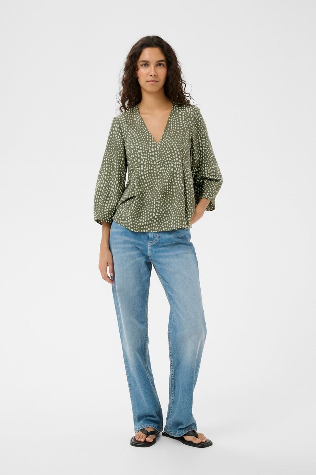 Blouse fluide imprimée Liberty avec encolure en V et manches longues bouffantes sur mannequin en jeans décontractés.