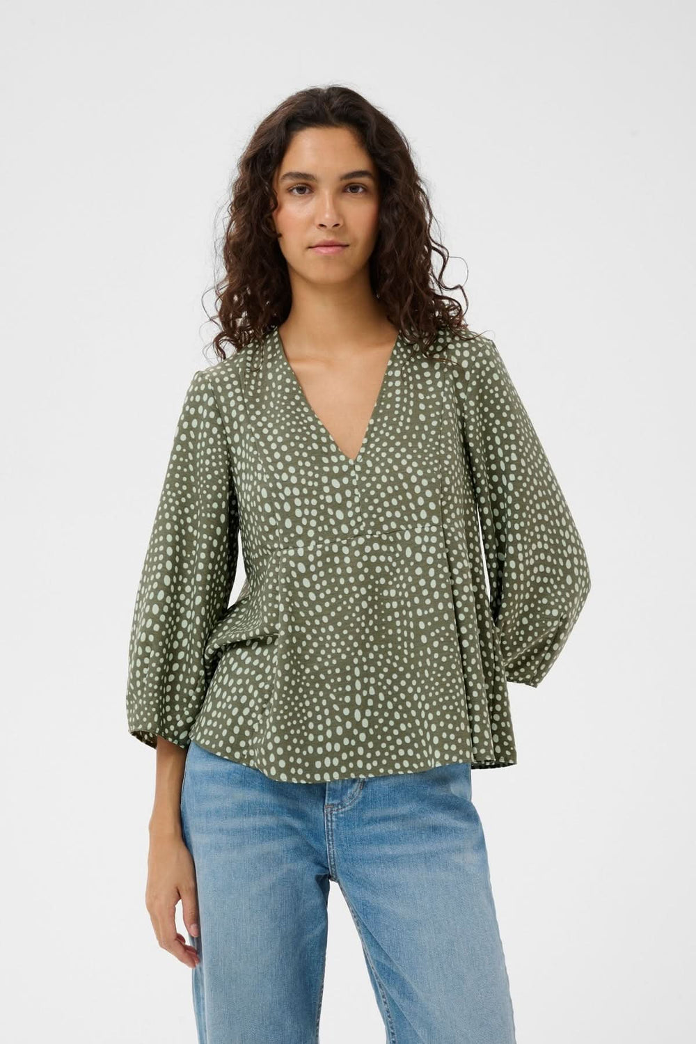 Blouse fluide imprimée Liberty avec encolure en V et manches longues bouffantes, silhouette élégante et décontractée.