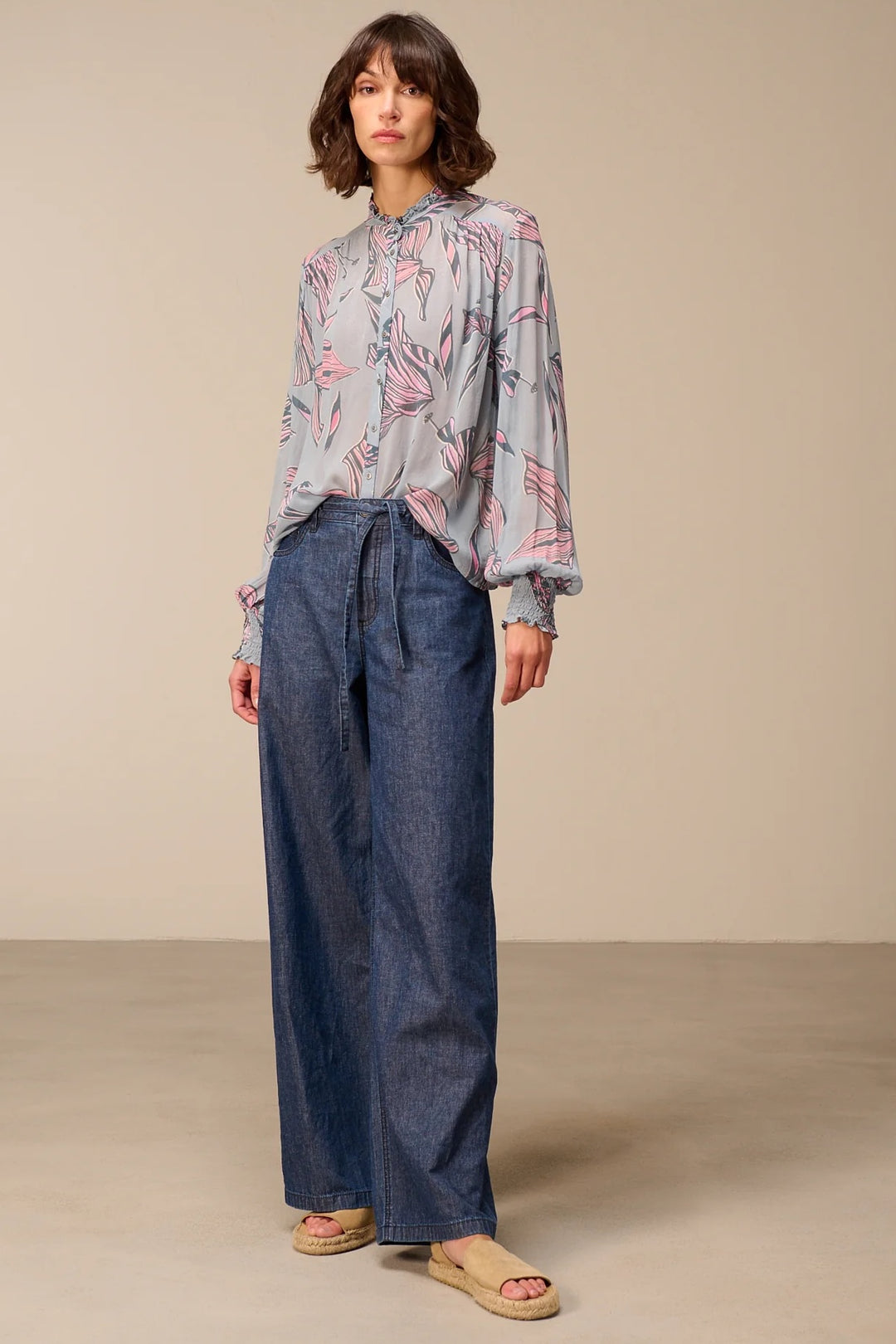 Blouse fluide à manches longues avec col montant froncé et poignets smockés, idéale pour une tenue élégante et féminine.