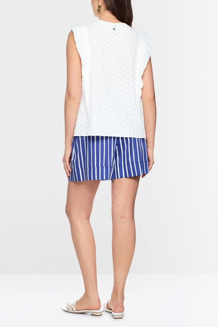 Femme portant une blouse féminine avec volants, sans manches, silhouette fluide, style estival, de dos, coupe ample, sur fond blanc.