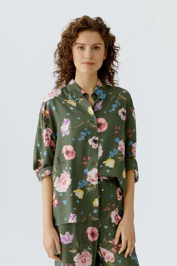 Blouse à imprimé floral fluide avec manches longues et col classique, idéal pour un look féminin et moderne.