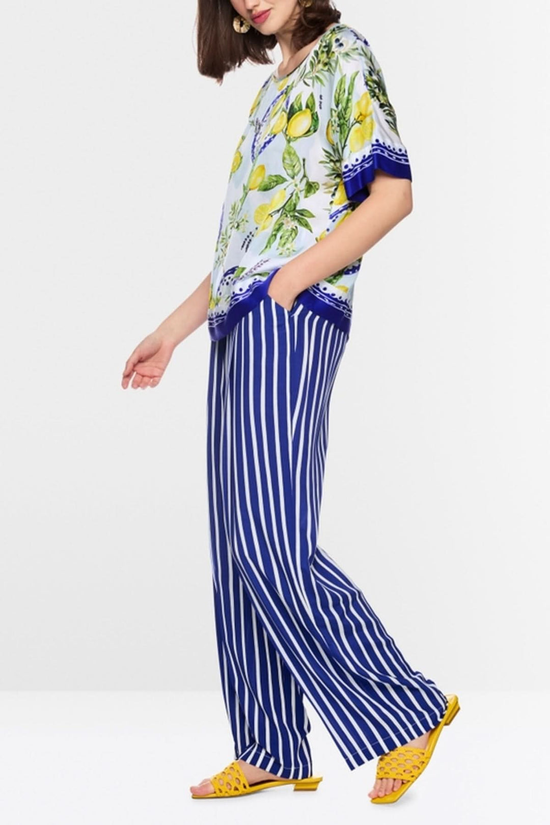Blouse imprimé méditerranéen en viscose fluide avec citrons et olives, manches mi-longues, col rond, porté par une femme.