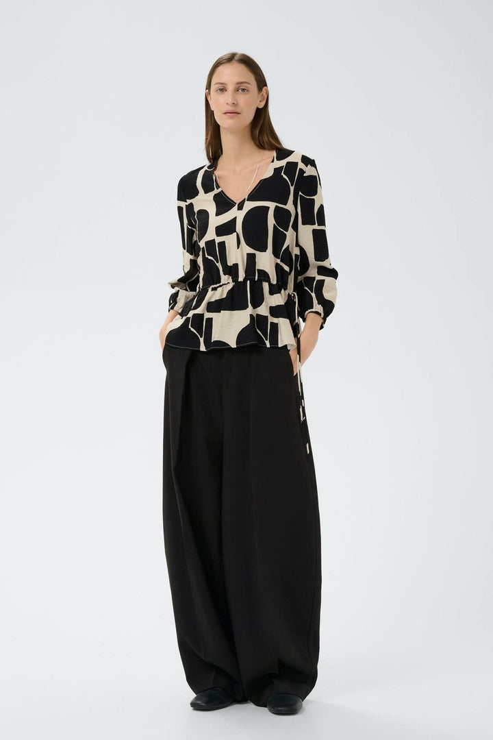 Blouse imprimée taille ajustable Lyn portée par mannequin, manches ¾ bouffantes, col en V, motif graphique, silhouette fluide.
