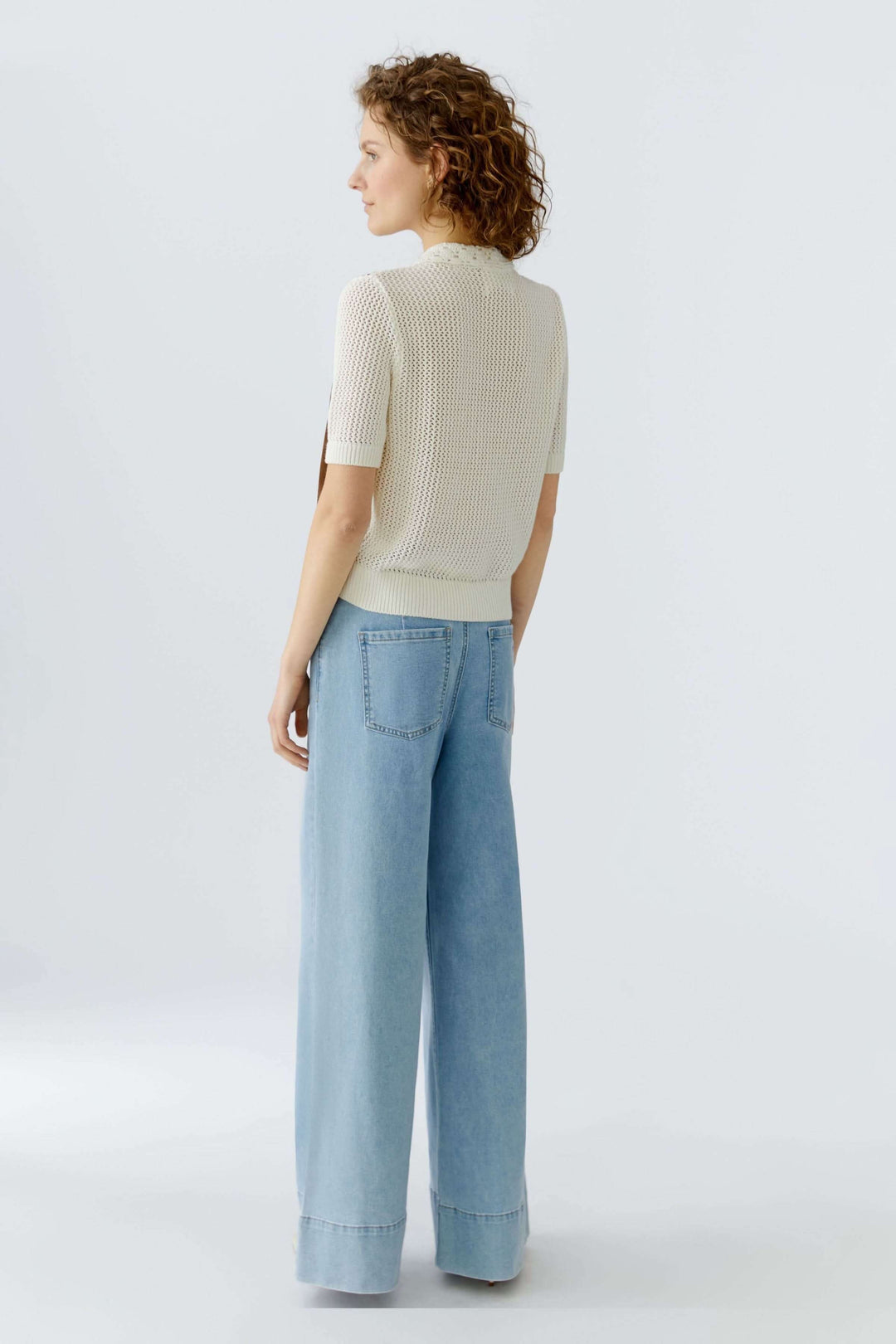 Blouse manches courtes avec col ajouré et détails contrastants, coupe droite valorisant la silhouette, vue de dos.