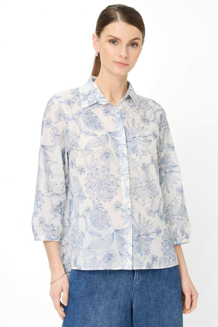 Blouse à motif floral VICKI avec manches trois-quarts et col classique, offrant une silhouette élégante et moderne.