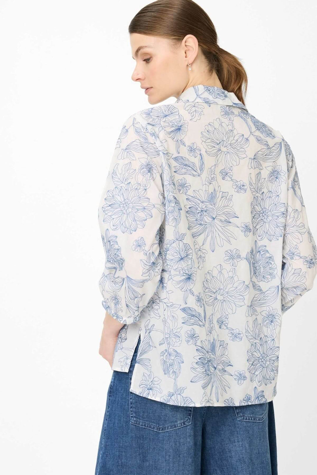 Femme portant une Blouse à motif floral VICKI avec manches trois-quarts et design élégant, vue de dos.
