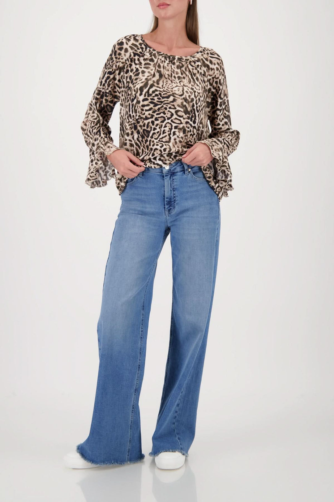 Blouse à motif léopard avec manches évasées et encolure ronde, portée avec un jean ample, style décontracté et élégant.