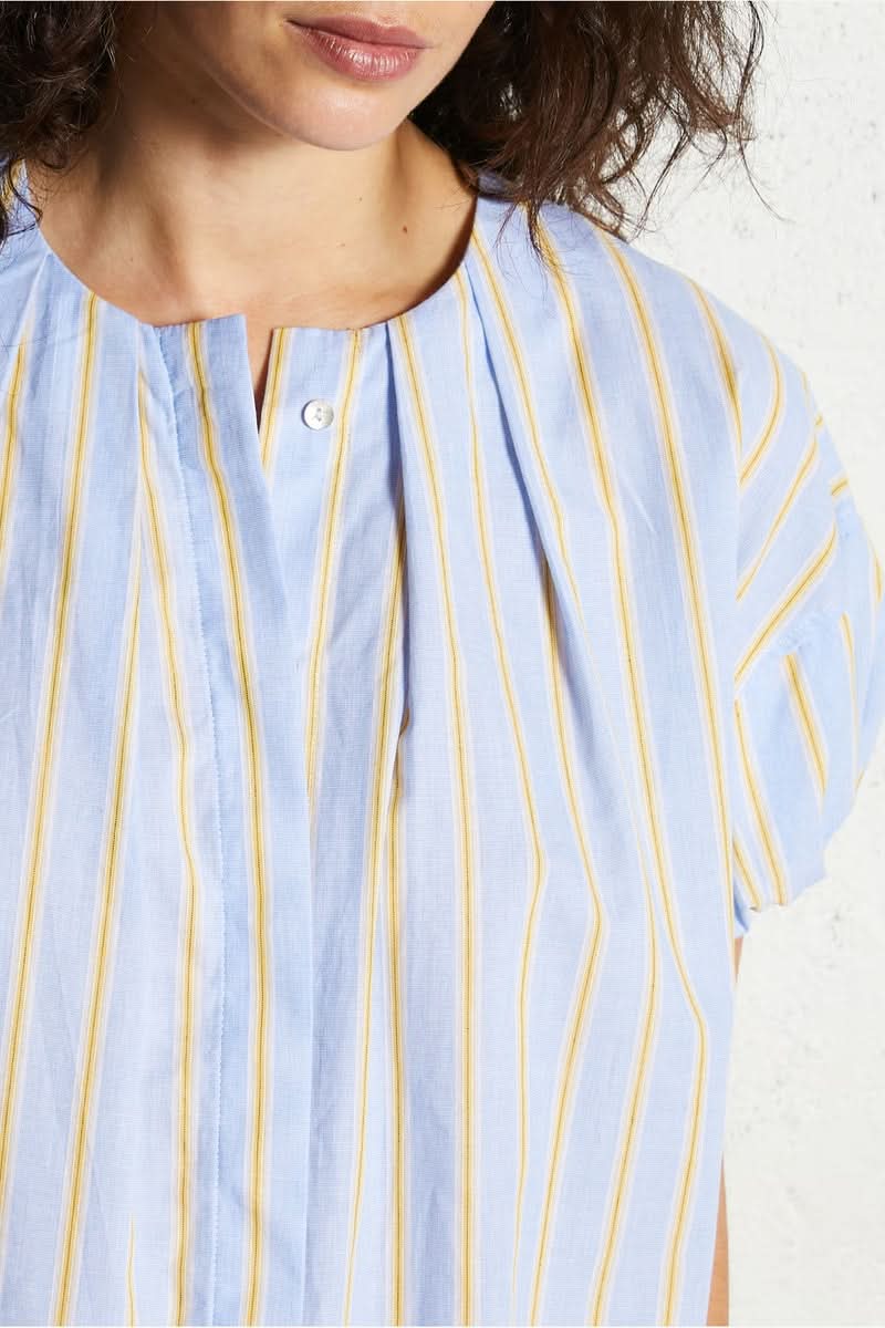 Blouse oversize à rayures bleues et jaunes, design épuré avec encolure en V subtile et manches courtes.