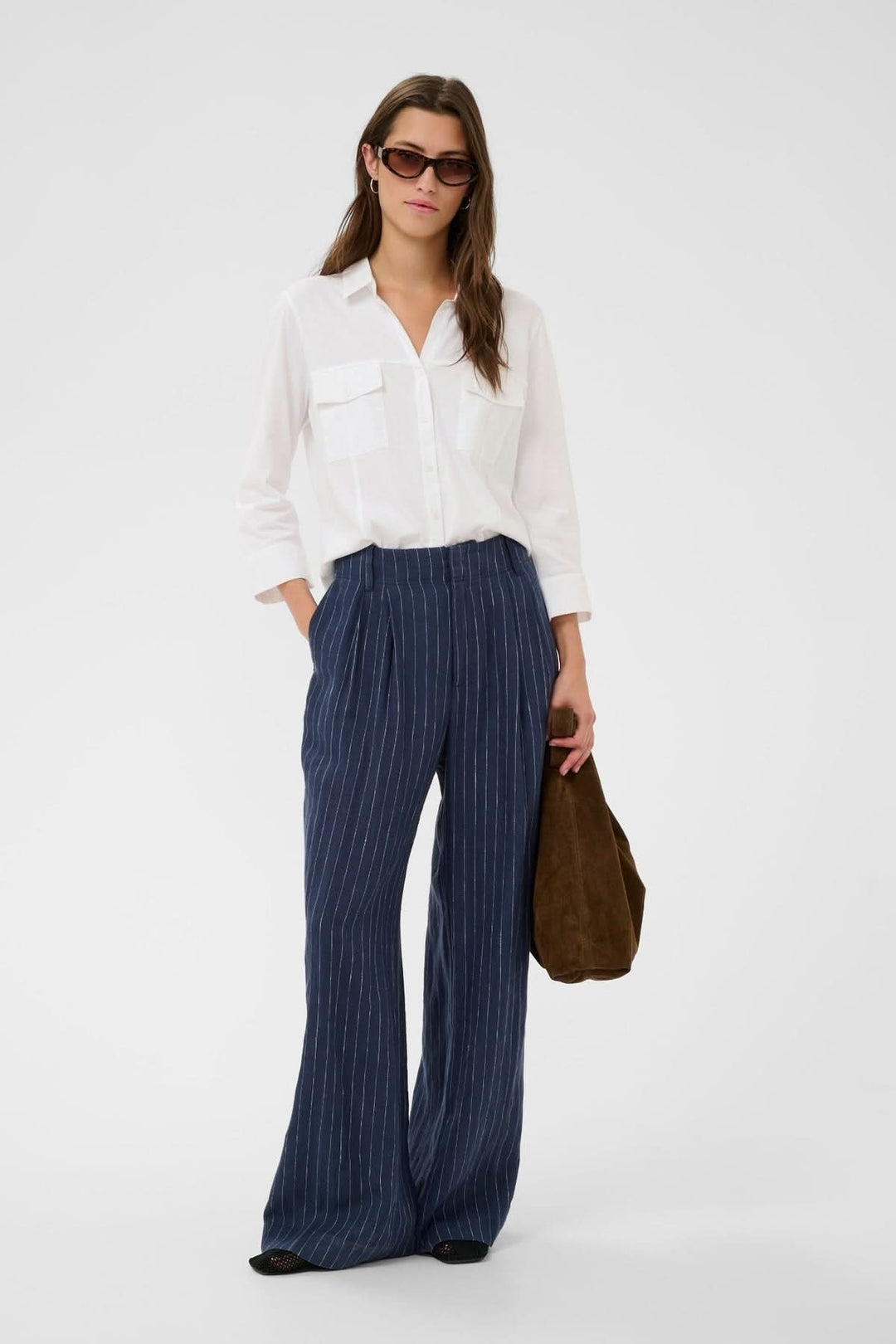 Modèle portant une blouse à poches utilitaires Anise, style moderne avec col chemise classique et coupe fluide, look quotidien élégant.