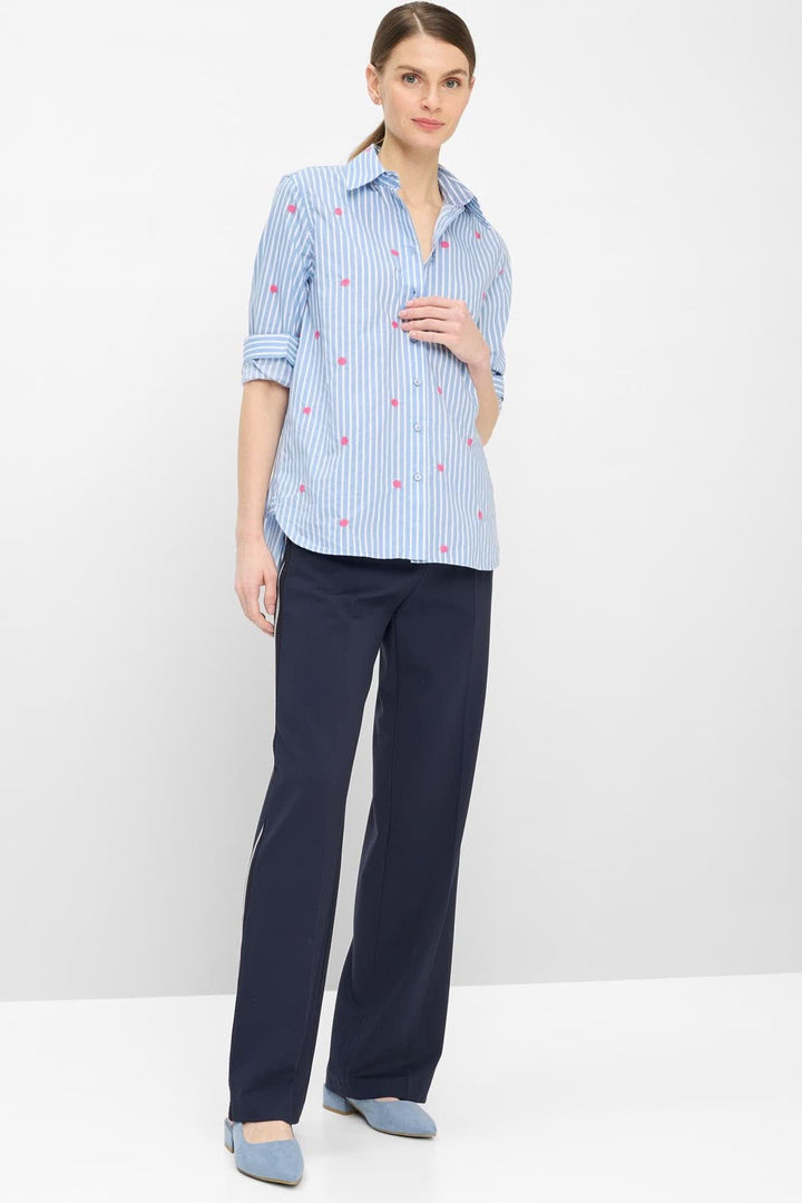 Blouse rayée à broderies contrastantes VIKI portée avec un pantalon bleu, montrant l'ajustement ample et les broderies délicates.