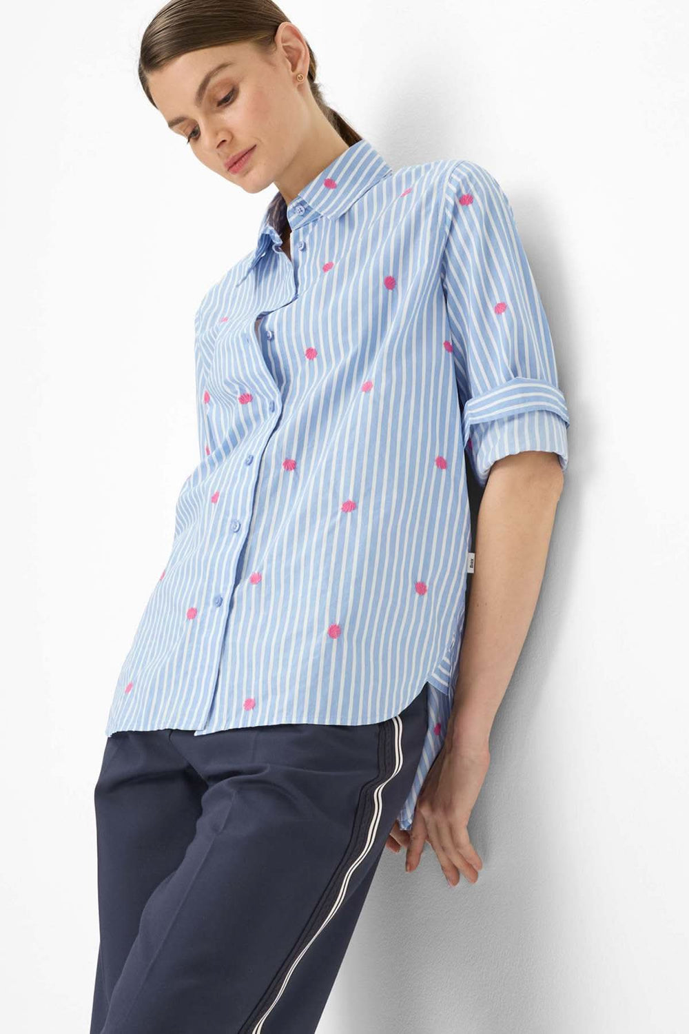 Femme portant la Blouse rayée à broderies contrastantes VIKI, coupe ample avec motif rayé et broderies, style moderne.