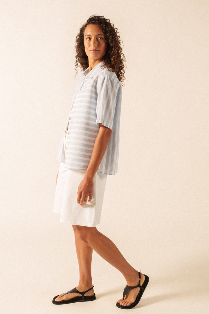 Blouse à rayures manches courtes ALMA, chemise légère d'été avec coupe droite et détails rayés, portée par un mannequin en sandales.