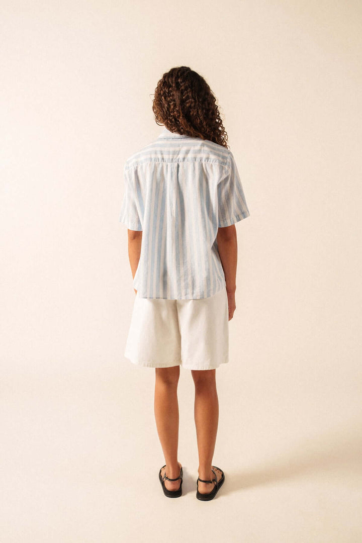 Vue arrière de la Blouse à rayures manches courtes ALMA, coupe droite et tissu léger, portée avec un short blanc, style estival décontracté.