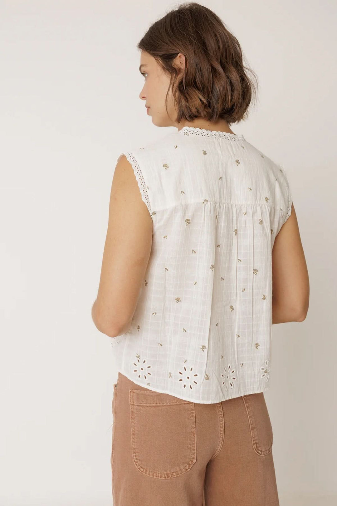Blouse sans manches à détails ajourés vue arrière, soulignant la bordure festonnée et les bandes ajourées pour un look féminin et élégant.