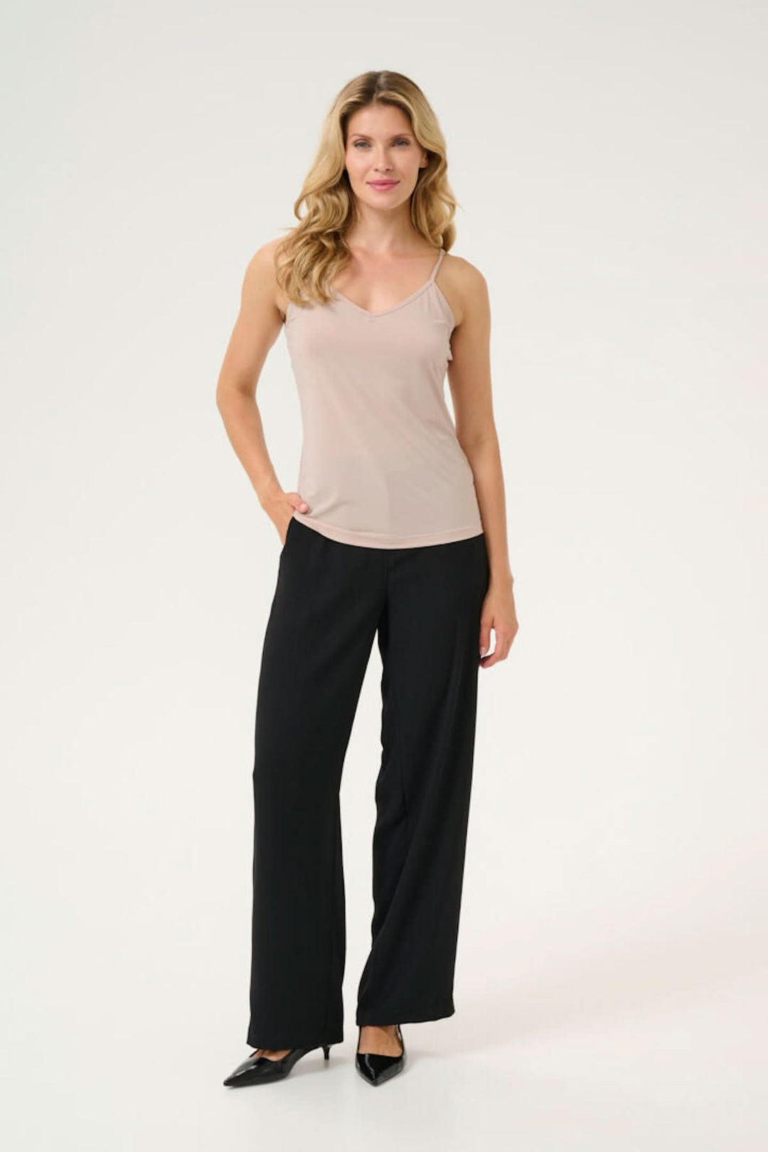 Camisole légère et ajustée avec mini bretelles, portée avec un pantalon noir, parfaite pour toutes les occasions.