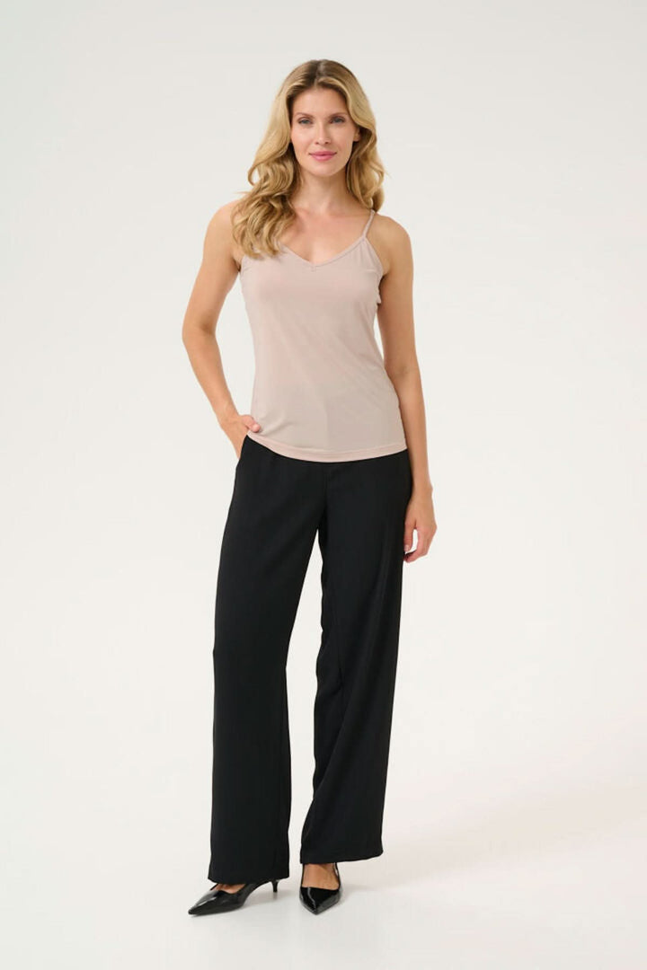 Camisole légère et ajustée avec mini bretelles, portée avec un pantalon noir, parfaite pour toutes les occasions.