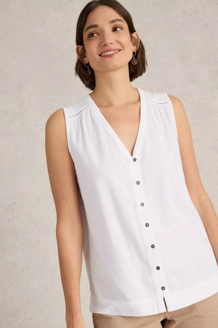 Camisole Delilah sans manches, col en V boutonné, style classique et estival, portée avec un sourire.