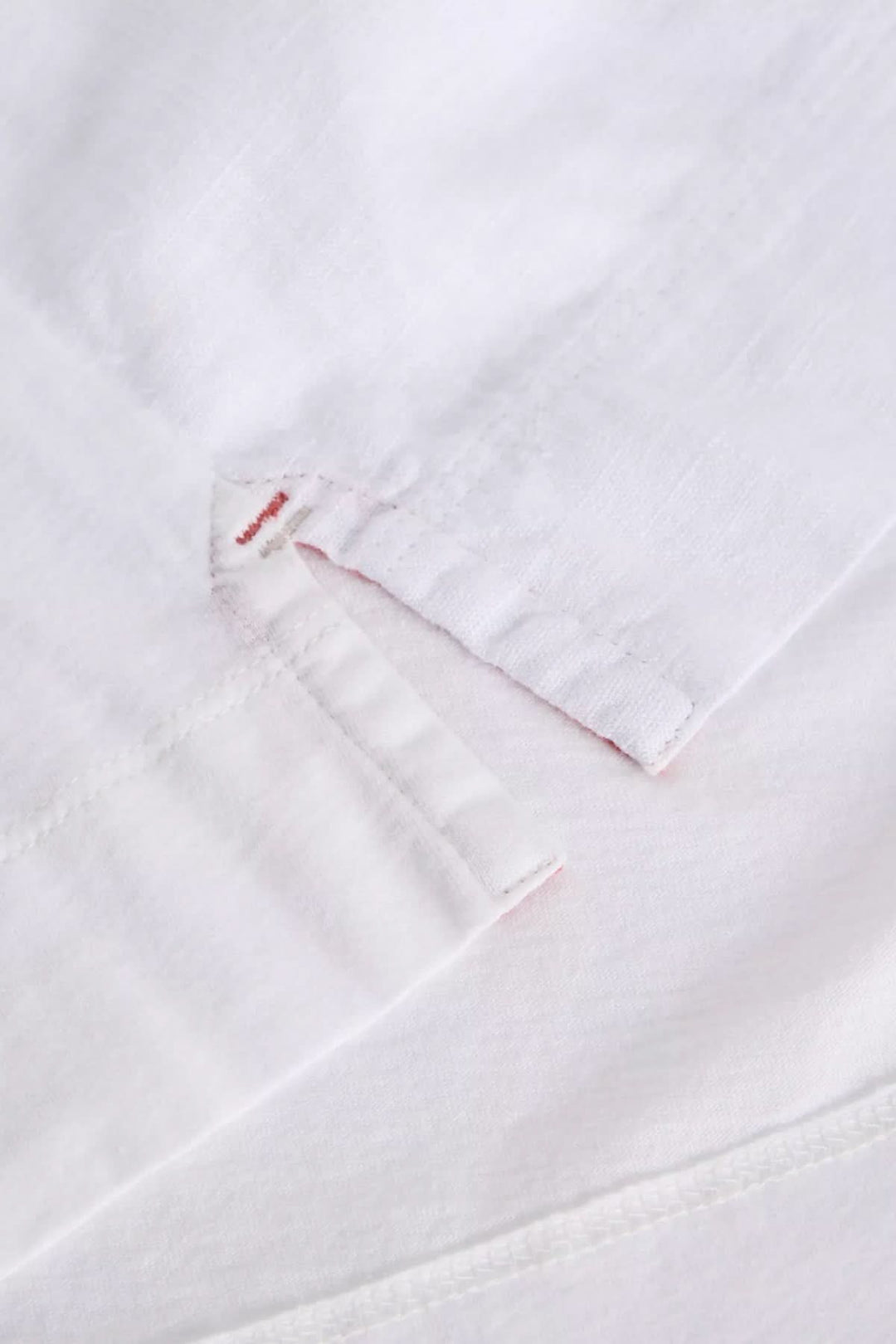 Détail de la camisole Delilah avec encolure en V et finition ajourée, tissu blanc légèrement texturé.