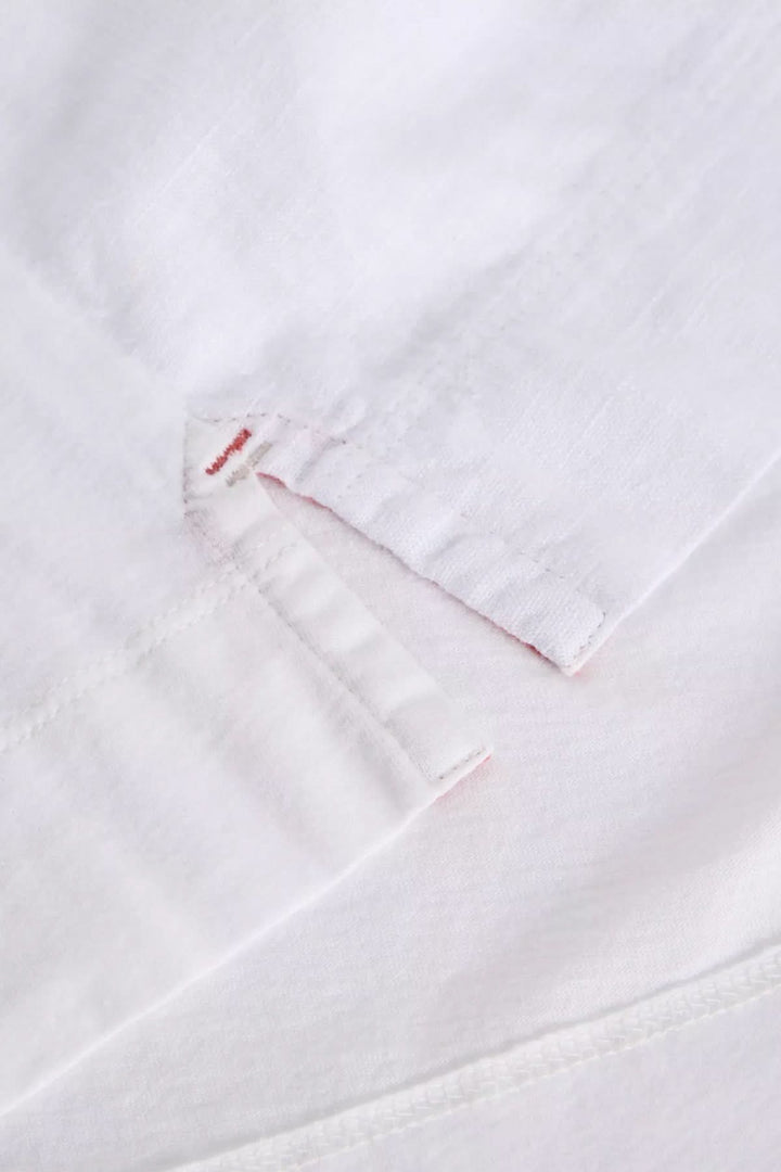 Détail de la camisole Delilah avec encolure en V et finition ajourée, tissu blanc légèrement texturé.