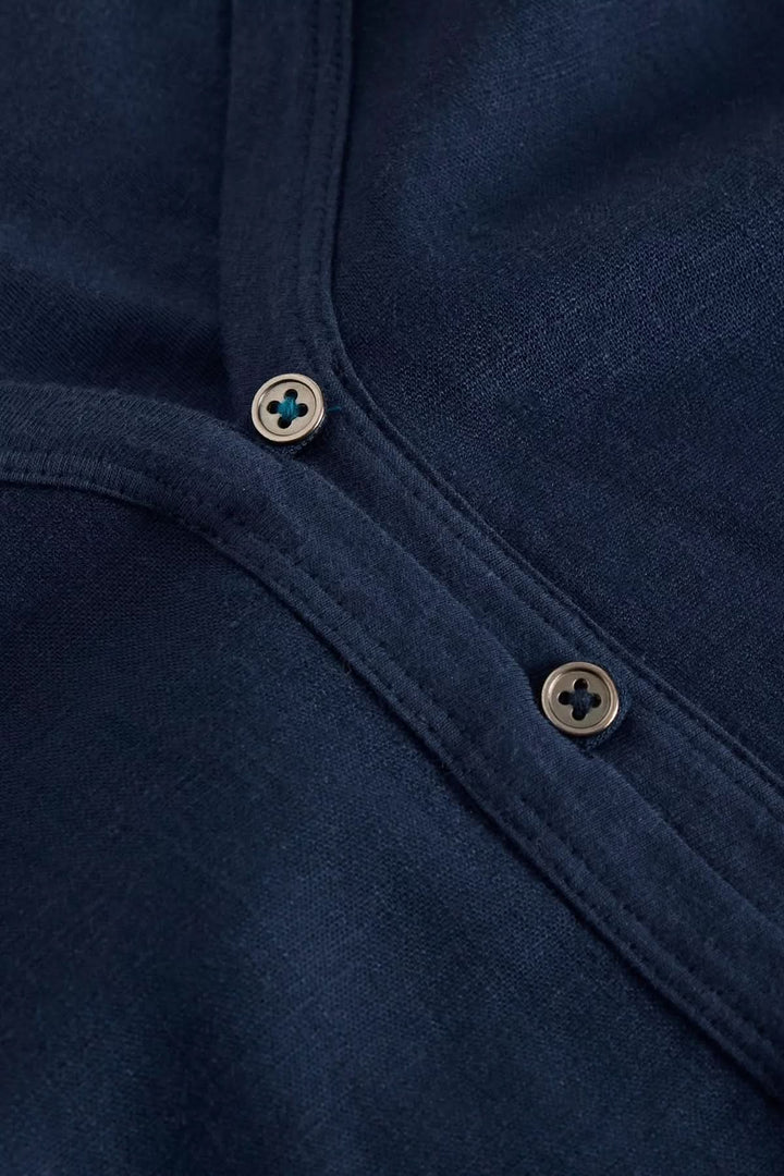 Détails du col en V boutonné de la camisole Delilah, en tissu fluide bleu marine.