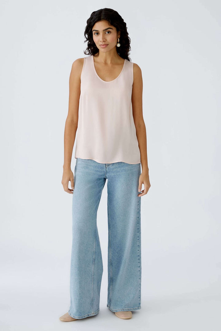 Camisole légère en viscose LENZING™ ECOVERO™, coupe flatteuse, associée à un pantalon ample en denim.