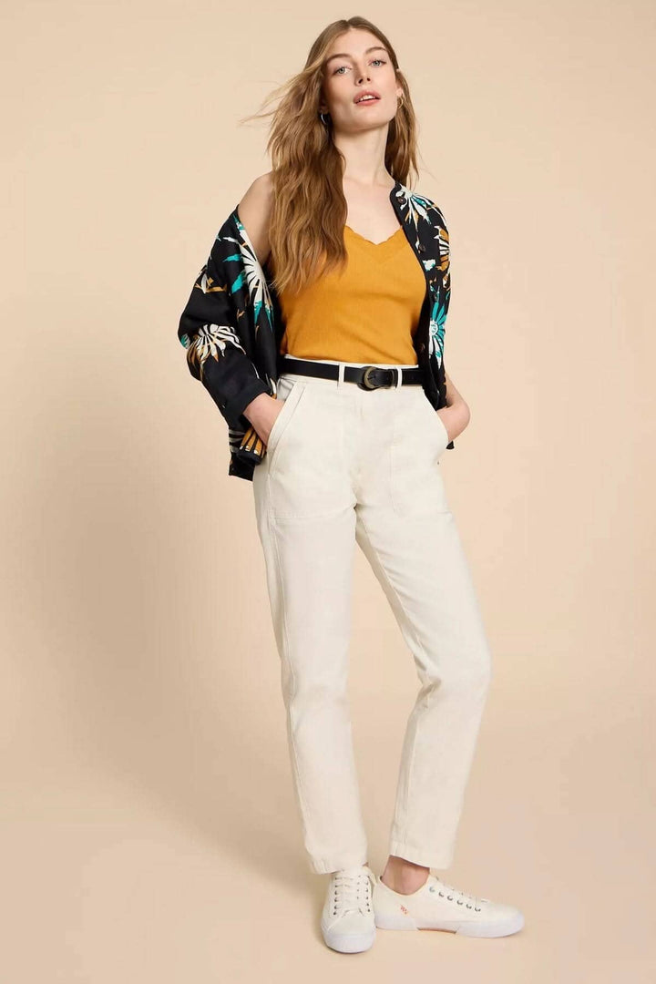 Camisole Seabreeze en couleur jaune portée avec un pantalon blanc et une chemise à motifs, tenue décontractée élégante.