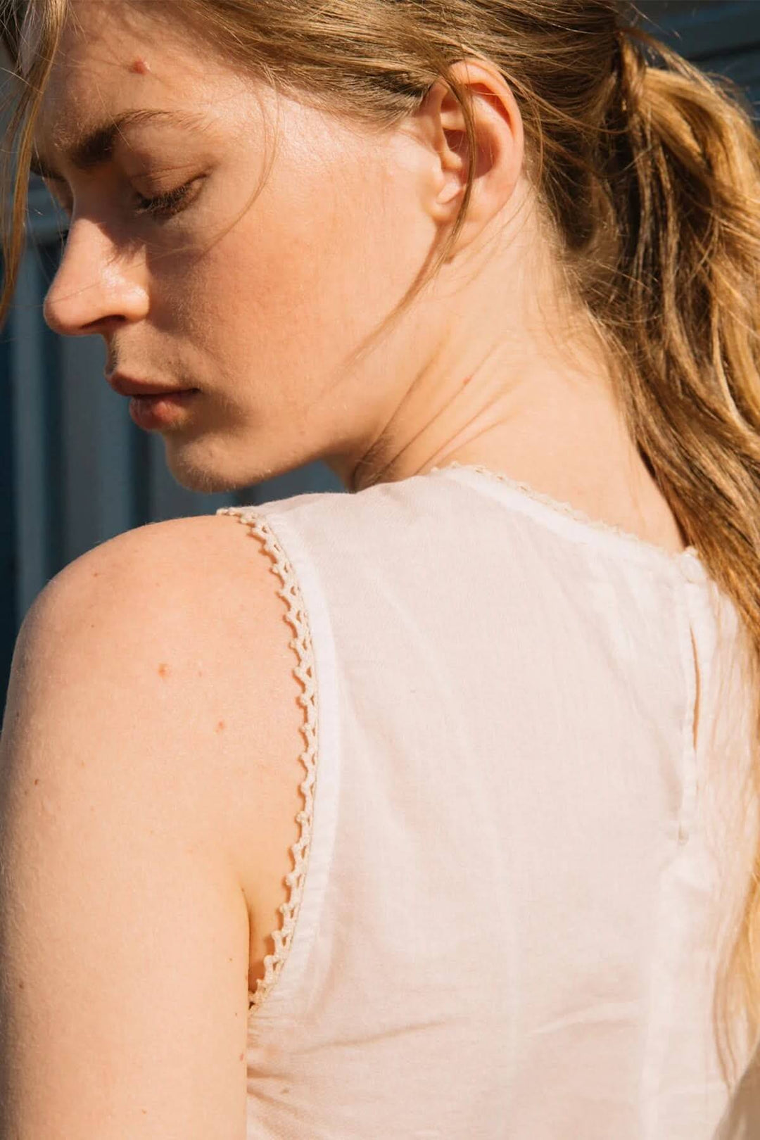 Feminine camisole showcasing delicate embroidered details and lace trim on the shoulders, perfect for a chic summer look.