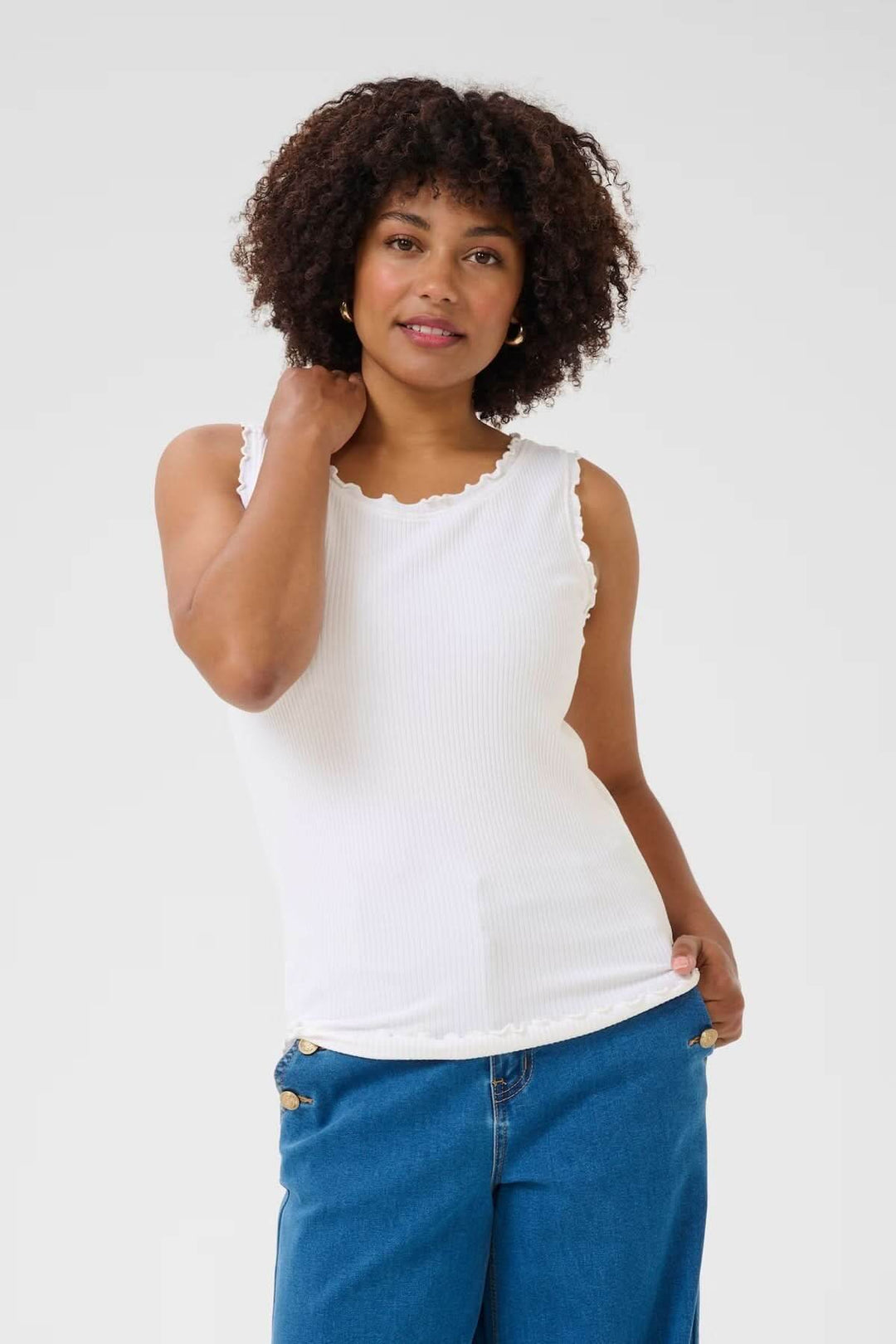 Camisole à col froncé blanche, légère et respirante, portée avec un jeans, idéale pour un look estival.