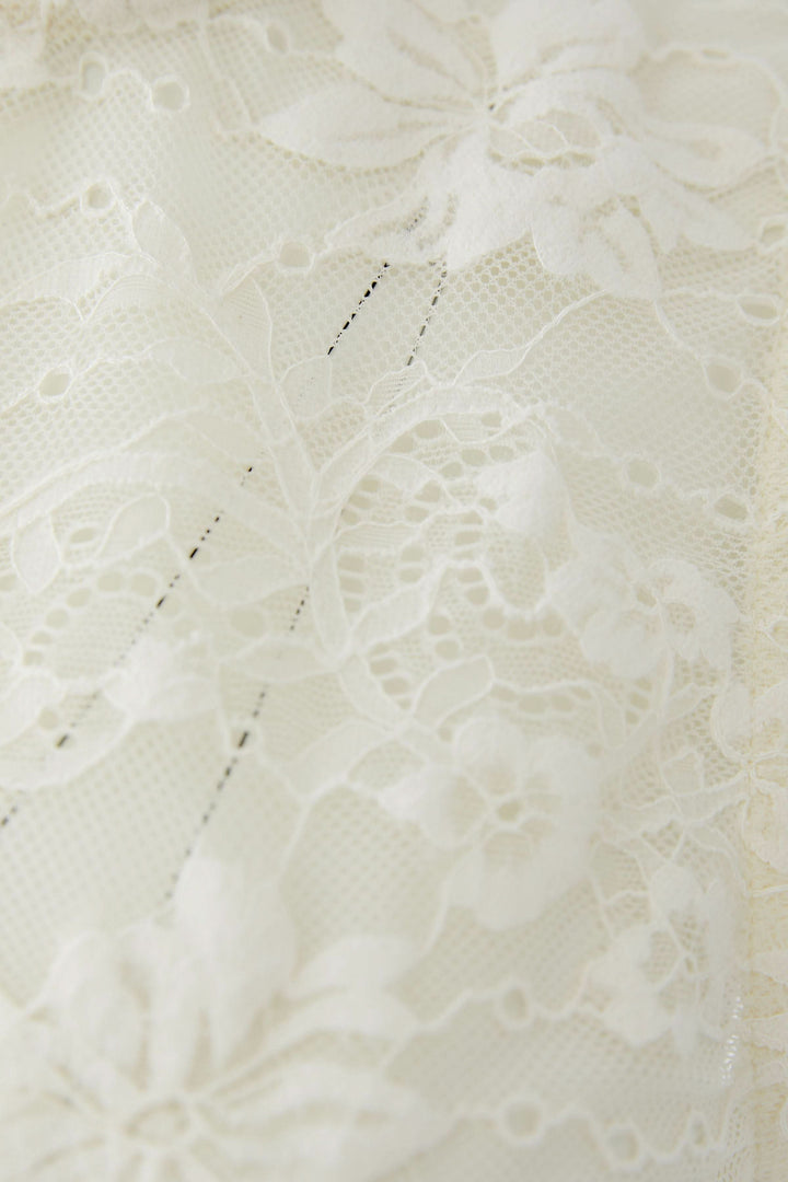 Détail de dentelle florale de la camisole en dentelle florale, affichant un motif délicat et raffiné.