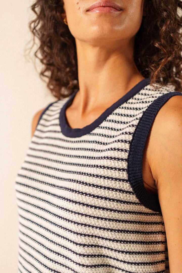 Femme portant une camisole en maille rayée MASSANE avec rayures fines et encolure côtelée, look moderne et épuré.