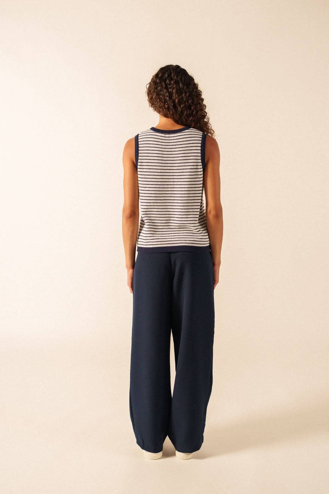Vue arrière de la Camisole en maille rayée MASSANE, portée avec un pantalon bleu, montrant le motif rayé et la coupe décontractée.