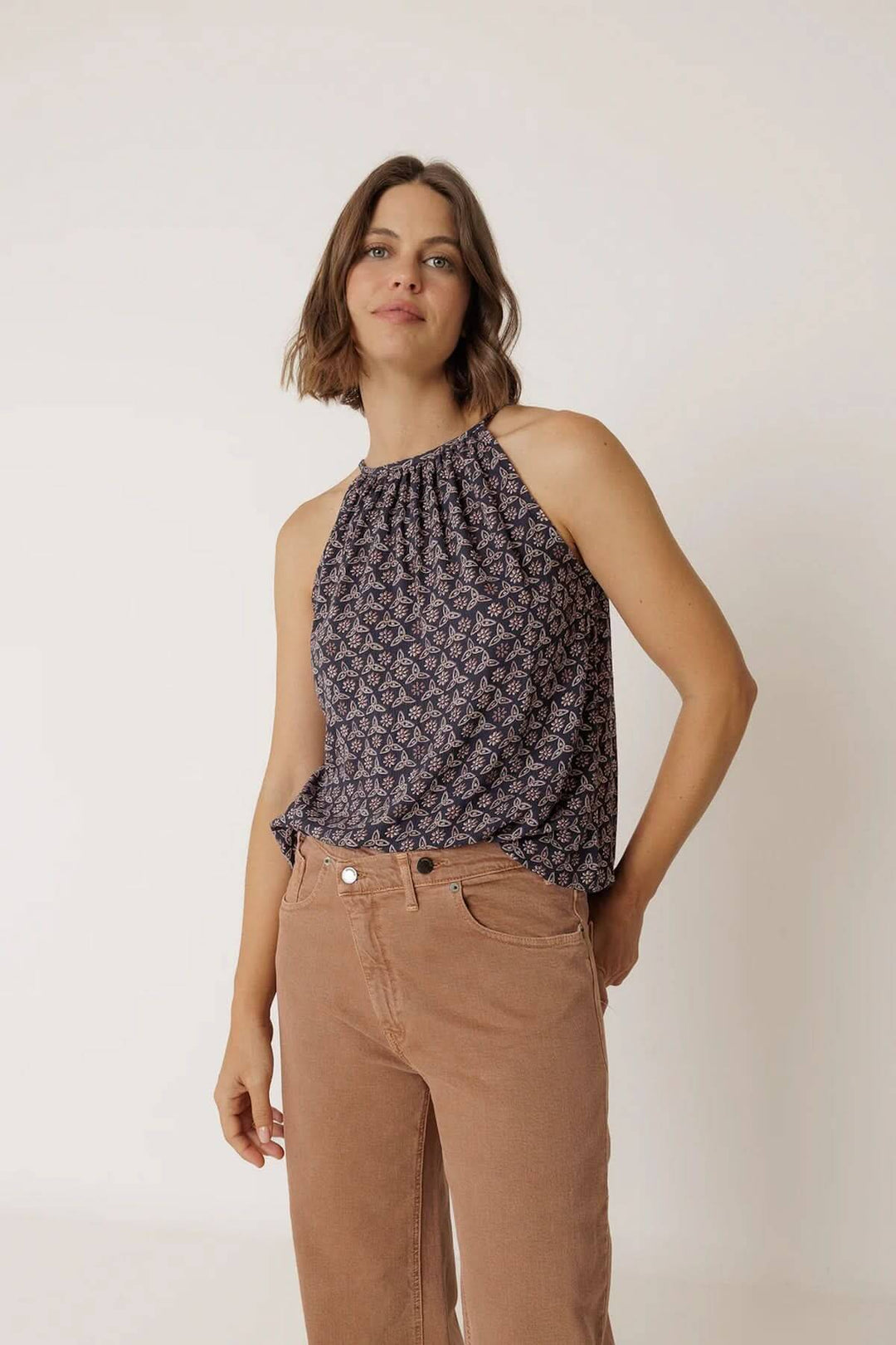Femme portant une camisole fluide à encolure froncée avec motif, coupe légère et ample, idéale pour un look estival élégant.