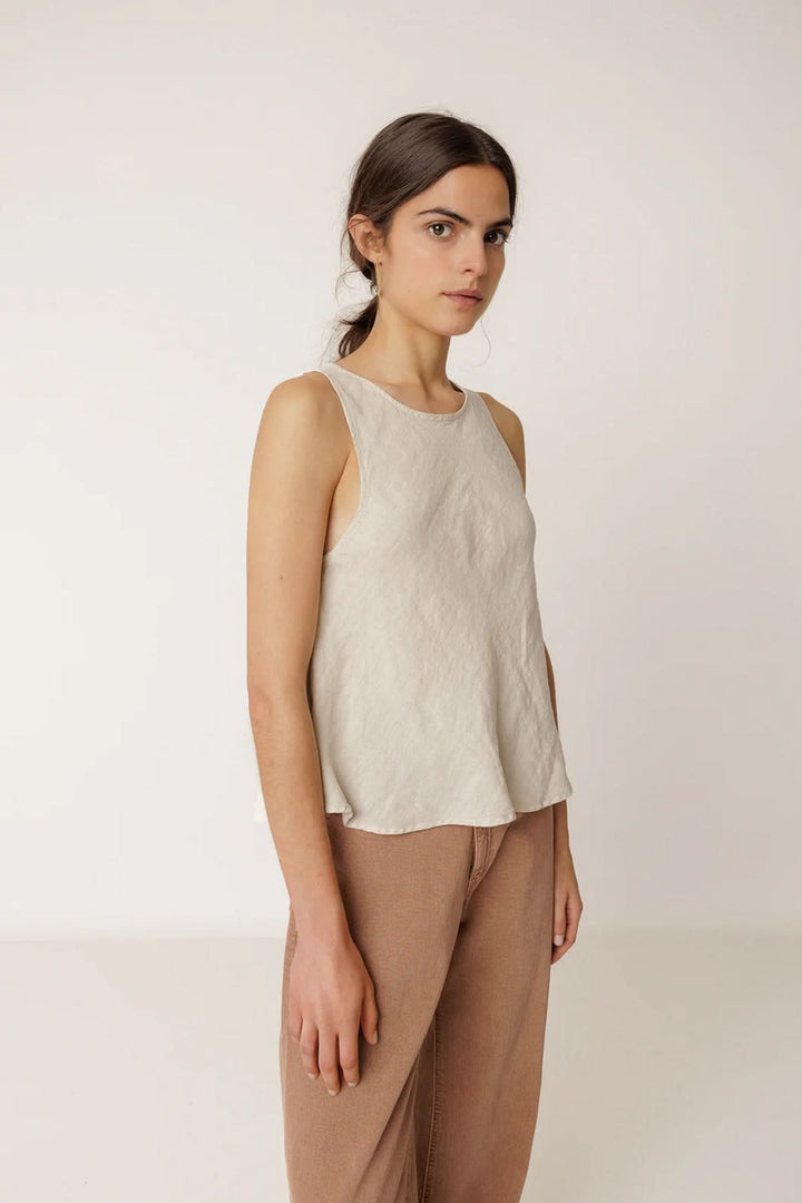 Camisole fluide sans manches à encolure ronde, coupe légèrement évasée et tissu léger, porté par un mannequin debout.