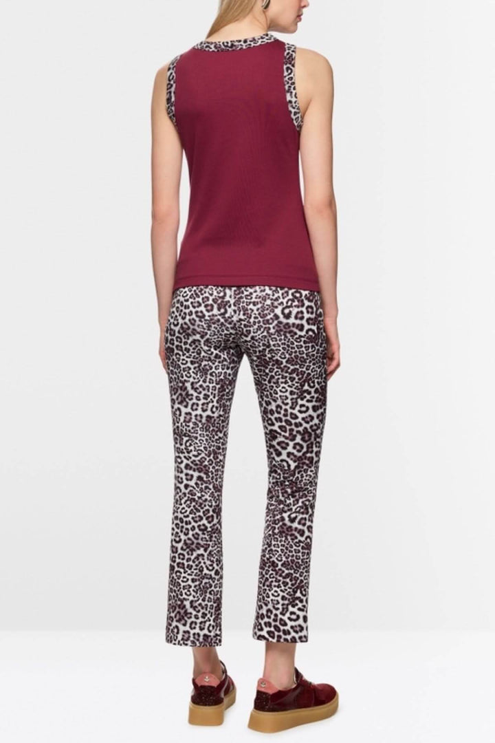 Femme portant une camisole à imprimé léopard avec col rond et coton stretch, détail unique au décolleté et aux emmanchures.