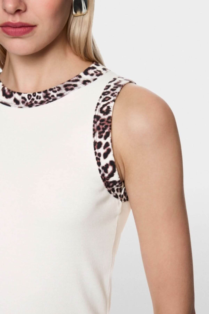 Femme portant une camisole à imprimé léopard en coton côtelé avec bordures léopard. Confort et élégance dans un style unique.