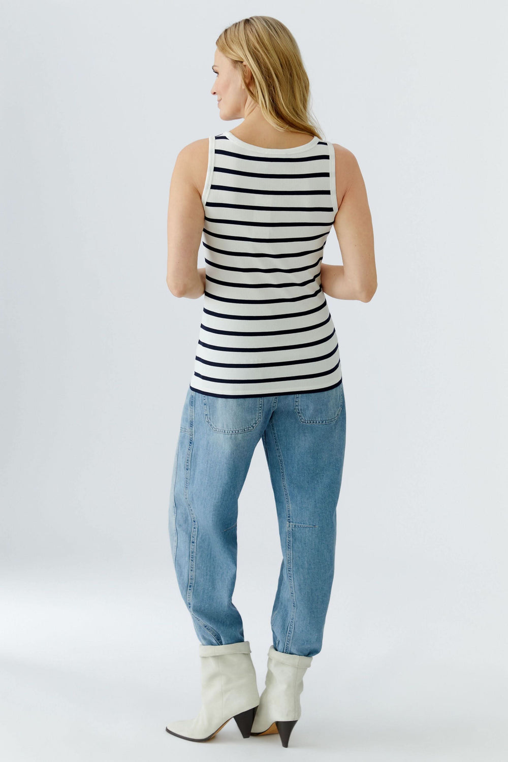 Femme portant une camisole rayée sans manches, vue de dos, style marin, coupe ajustée, parfait pour une silhouette féminine et épurée.