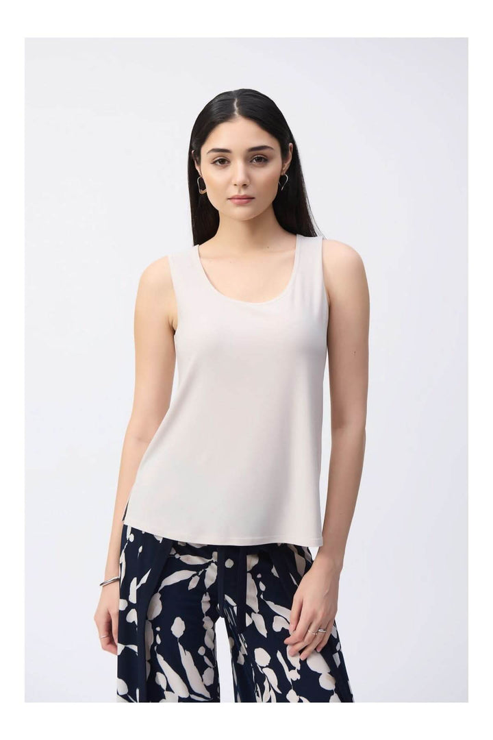 Camisole soyeuse à col rond portée par une femme, design épuré et tombé naturel, plan serré, style élégant et intemporel.