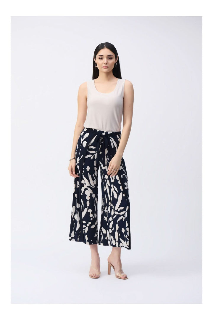 Femme portant une camisole soyeuse à col rond avec pantalon à motifs, style élégant et fluide.