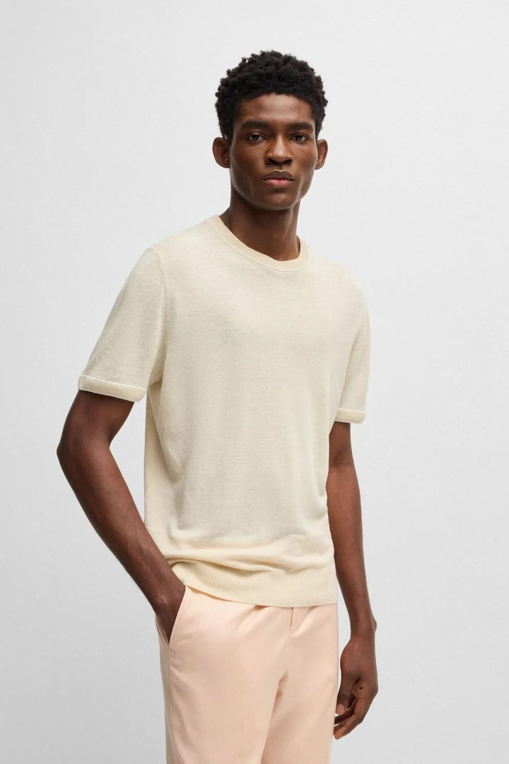 Homme portant un chandail léger en maille fine de couleur crème, associé à un pantalon pastel.