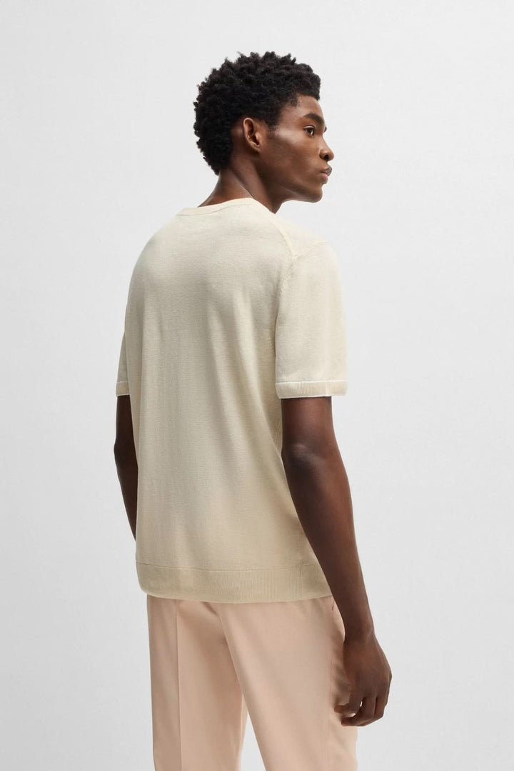 Homme portant un chandail en maille légère à manches courtes, vue arrière, avec un style élégant et décontracté.