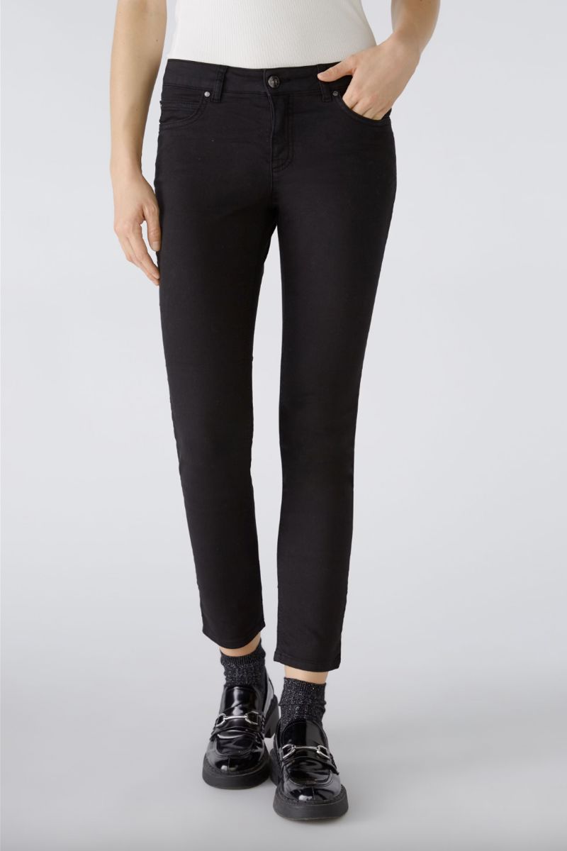 Pantalon ajusté noir avec taille régulière et longueur au-dessus des chevilles, porté par un mannequin.